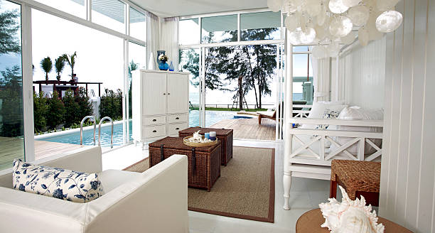 Salon ouvert sur piscine avec meubles en bois et canapé blanc