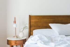 chambre avec lit avec tête de lit en bois et table de chevet en bois